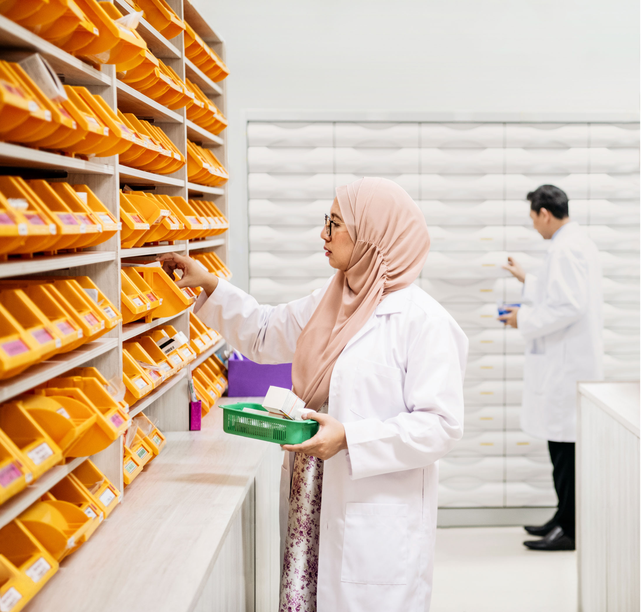 Pharmacist retrieving medication from pharmacy shelves
